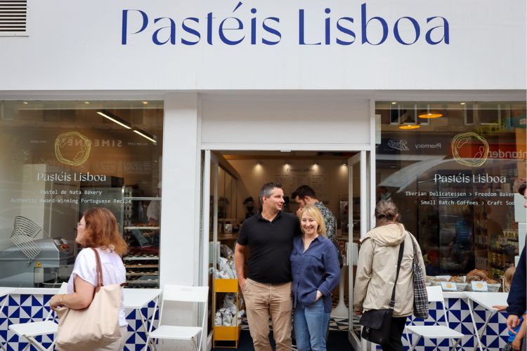 Co-owners Sebastian and Emma standing under the Pasteis Lisboa storefront.